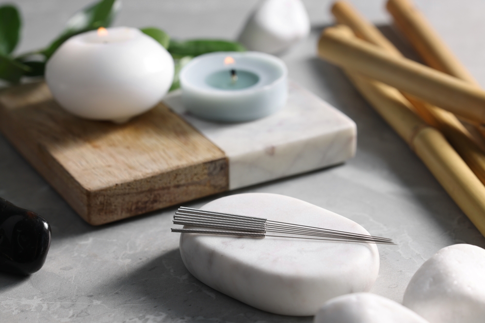 Stone,With,Acupuncture,Needles,On,Light,Grey,Marble,Table