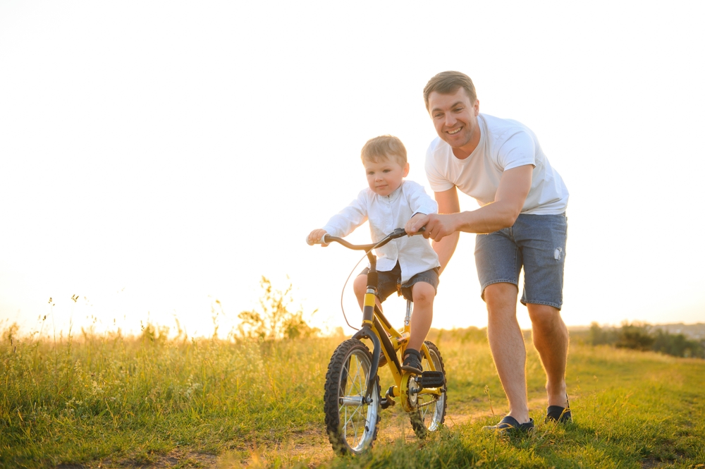 Father,Teaching,His,Son,How,To,Ride,A,Bicycle.